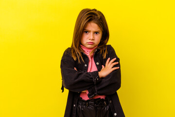 Little caucasian girl isolated on yellow background blows cheeks, has tired expression. Facial...