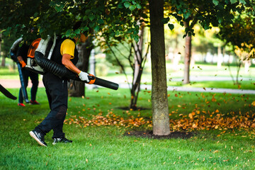 A woman operating a heavy duty leaf blower.