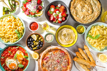 Set of different Mediterranean foods: olives, mozzarella and tomato salad, Greek salad, pasta,...