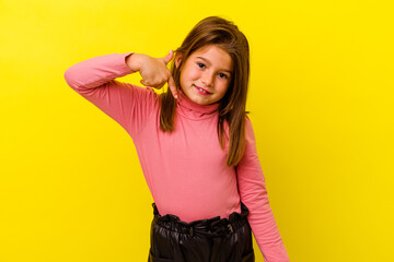 Little caucasian girl isolated on yellow background person pointing by hand to a shirt copy space,...