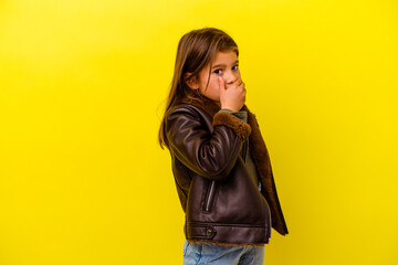 Little caucasian girl isolated on yellow background scared and afraid.