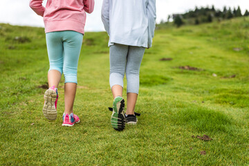 Children hiking in mountains or meadows with sport hiking shoes.