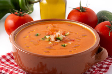 Gazpacho soup in crock pot and ingredients isolated on white background