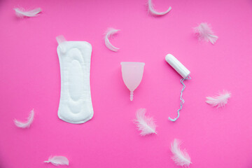 Sanitary pad, menstrual cup, tampon on a pink background. Flat lay. Female hygiene during the menstrual cycle.Concept of critical days, menstruation. 