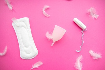 Sanitary pad, menstrual cup, tampon on a pink background. Flat lay. Female hygiene during the menstrual cycle.Concept of critical days, menstruation. 