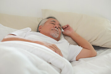 Asian Elderly man sleep and sweet dream on bed.
