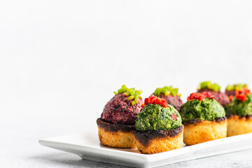 Georgian spinach and beetroot pkhali on mchadi cornbread with bell pepper garnish