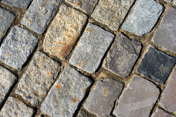 The texture of the stone pavement. Background of granite cobblestone pavement. Abstract background of an old cobblestone street close-up. Moscow