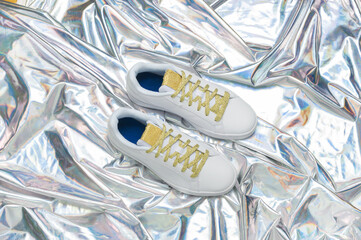 White womens sneakers on a silver background