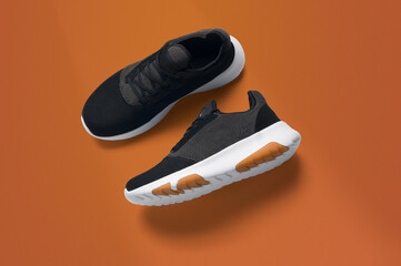 black sneakers with orange sole on a orange backgroun