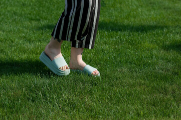 Girl in flip flop walking on a grass