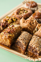 Assortment of Ramadan dessert baklava on green background