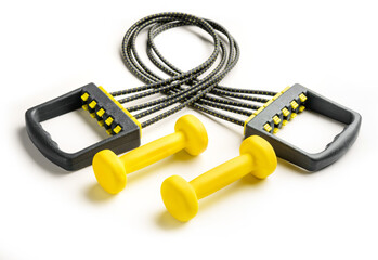 Yellow dumbbells and expander isolated on a white background close-up.