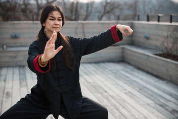 Female athlete perfecting tai chi form in the open air