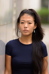 Portrait of beautiful rebel Asian woman outdoors