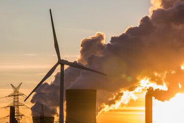 Windrad, Windräder vor dampfenden Kohlekraftwerk bei Sonnenuntergang, Energiewende, fossile und...
