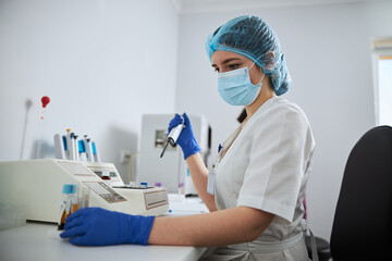 Focused lab technician preparing clinical specimens for a coagulation analysis