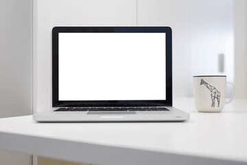 Laptop with blank screen and mug on a table.	
