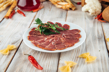 Dried tenderloin basturma platter on the wooden background