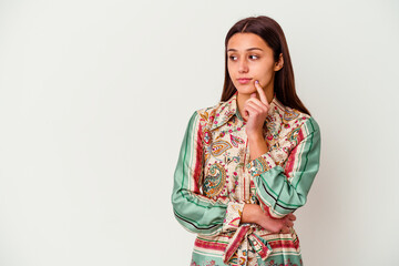 Young Indian woman isolated on white background looking sideways with doubtful and skeptical...