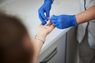Obraz na płótnie Canvas Nurse using a finger prick method for a hematological test