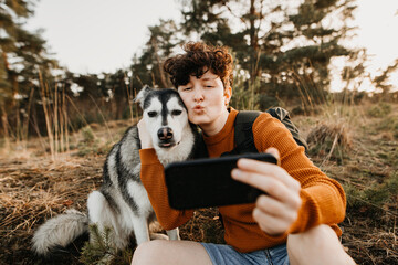 Junger Mensch und Hund machen Duckface Selfie 