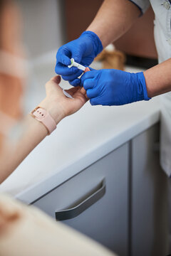 Nurse carrying out a finger prick test using a lancet
