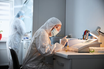 Naklejka premium Two virologists performing chemical tests in a research lab
