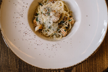 Bowl of spaghetti with shrimps and parmesan cheese. Top view.