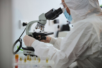 Lab technician examining an antiviral drug through the microscope