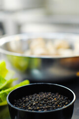 Pepper peas and salt in bowls on the kitchen table.