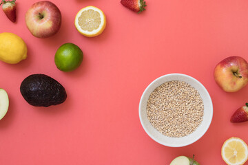 Bowl of breakfast cereal with fresh seasonal fruits on pink background