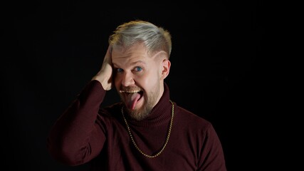 Comical stupid stylish man with blue eyes in trendy clothes making funny awkward silly face...