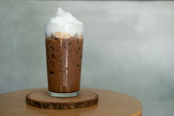 Glass of iced mocha coffee with milk foam, espresso mixed with chocolate or cocoa topped with milk foam.