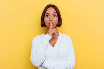 Young mixed race woman isolated on yellow background keeping a secret or asking for silence.