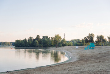 Beautiful river morning with fog and sunlight. Sand, sunbathing area and lifeguard house. Warm, colorful look.