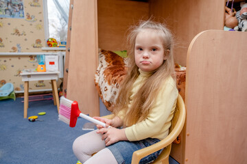 A child with Down syndrome is playing in his home. Haronic development of a girl with down syndrome.