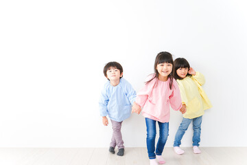 Fototapeta premium 壁に並ぶ3人の幼稚園児