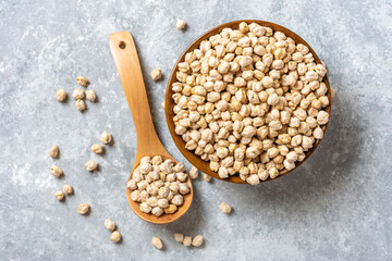 dry chickpeas in wooden bowl on concrete background Healthy eating, vegetable protein concept Top...