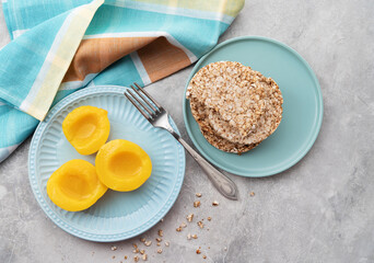 Sliced canned yellow peach with syrup on a blue plate