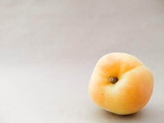 Close up apricot on beige background with copy space. Texture of yellow ripe apricot fruit. Summer berries and fruits. Seasonal harvest.