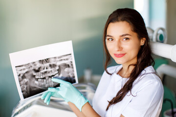 Close up woman dentist holding patient mouth digital film.The dentist explained about the oral cavity to the patient at the dental office