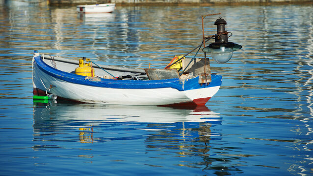 Traditional colourful maltese luzzu fishing boat anchored in harbour, Marsaxlokk, Malta