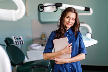 Young doctor in a dental clinic. Portrait of young female doctor dentist with digital tablet in dental office