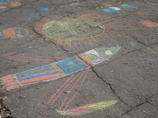 Child's chalk drawing of rocket on asphalt, space theme, April 12
