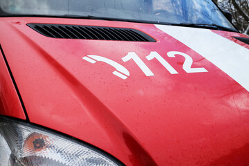 Common european and worldwide emergency number 112 on the vehicle of the emergency services brigade