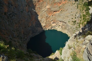 Fototapeta premium Red Lake is a red lake coloured thanks to high ratio of iron in the rocks in Dalmatia, Croatia