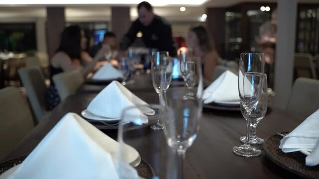 cutlery and bowls on the table in a restaurant for events with guests and a waiter serving