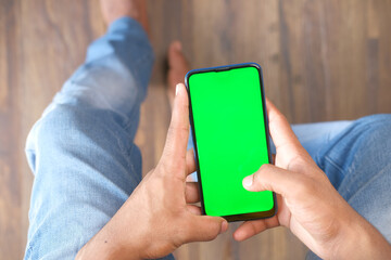 rear view of young man using smart phone indoor 