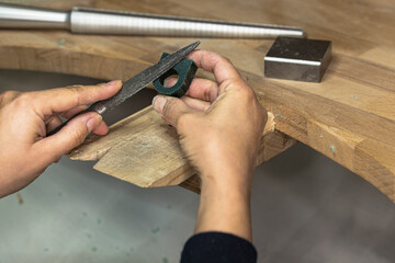 Female jeweler sculpting the wax form of the ring from the ring tube.
